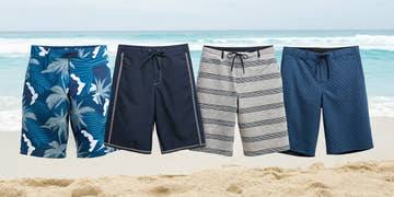 Four different types of swim suits for men, from trunks to briefs, arranged on a sandy beach.