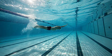 Swimmer using short fins for swimming to build a faster, stronger kick.