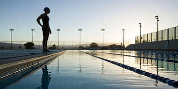 A serious swimmer in a durable training swim suit prepares for practice.
