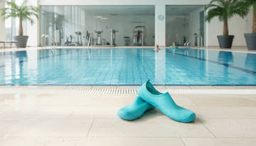 Supportive water aerobics shoes beside a swimming pool