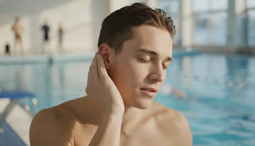 Swimmer tilting head to drain water from ear after swimming