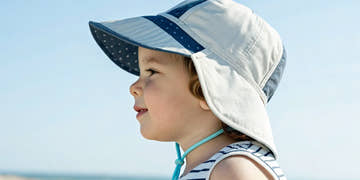 Young kid wearing a wide-brim sun cap for sun safety.