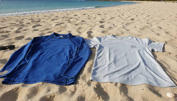 Snug athletic rash guard next to relaxed swim shirt on a sunny beach