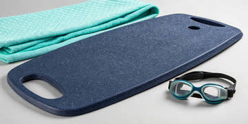 A Speedo kickboard for swim training resting on the pool deck.