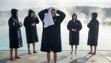 Swimmers in warm Speedo swim parkas standing poolside in the cool morning air