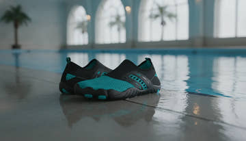 Swim shoes beside a bright indoor swimming pool