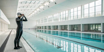 Swimmer in a tech suit preparing for a competitive swimming race.
