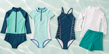 A collection of girls swim suits including a blue rashguard, a green one-piece, and swim shorts.