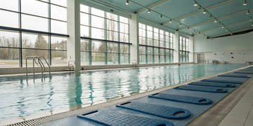 Blue kickboards on a pool deck for swim training to build leg strength and improve technique.