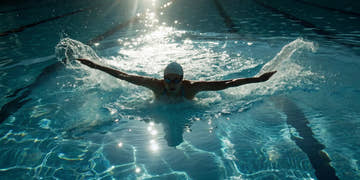 Swimmer wearing a drag suit for resistance training during butterfly stroke.